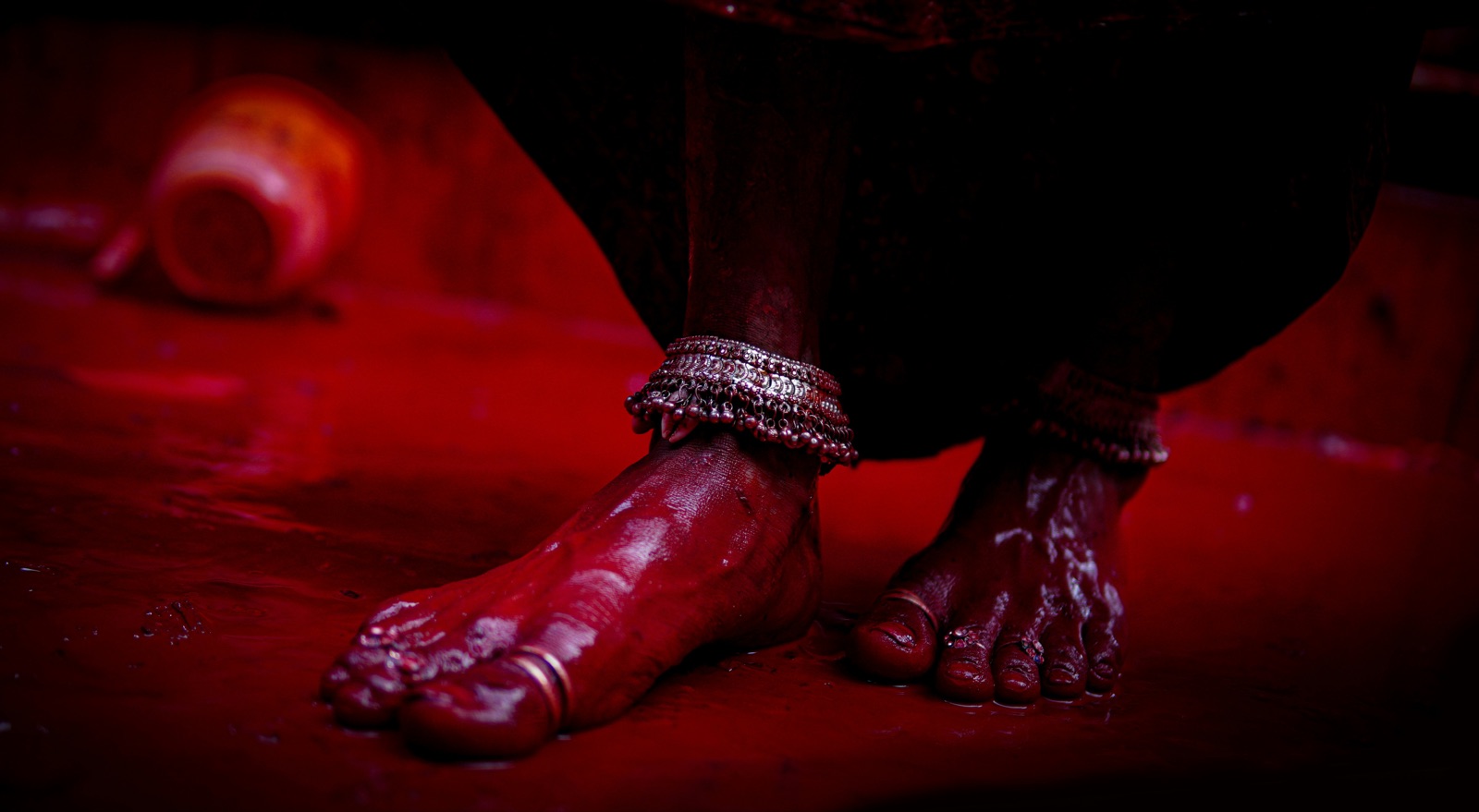 Bridal feet decorated with red alta on a red backdrop