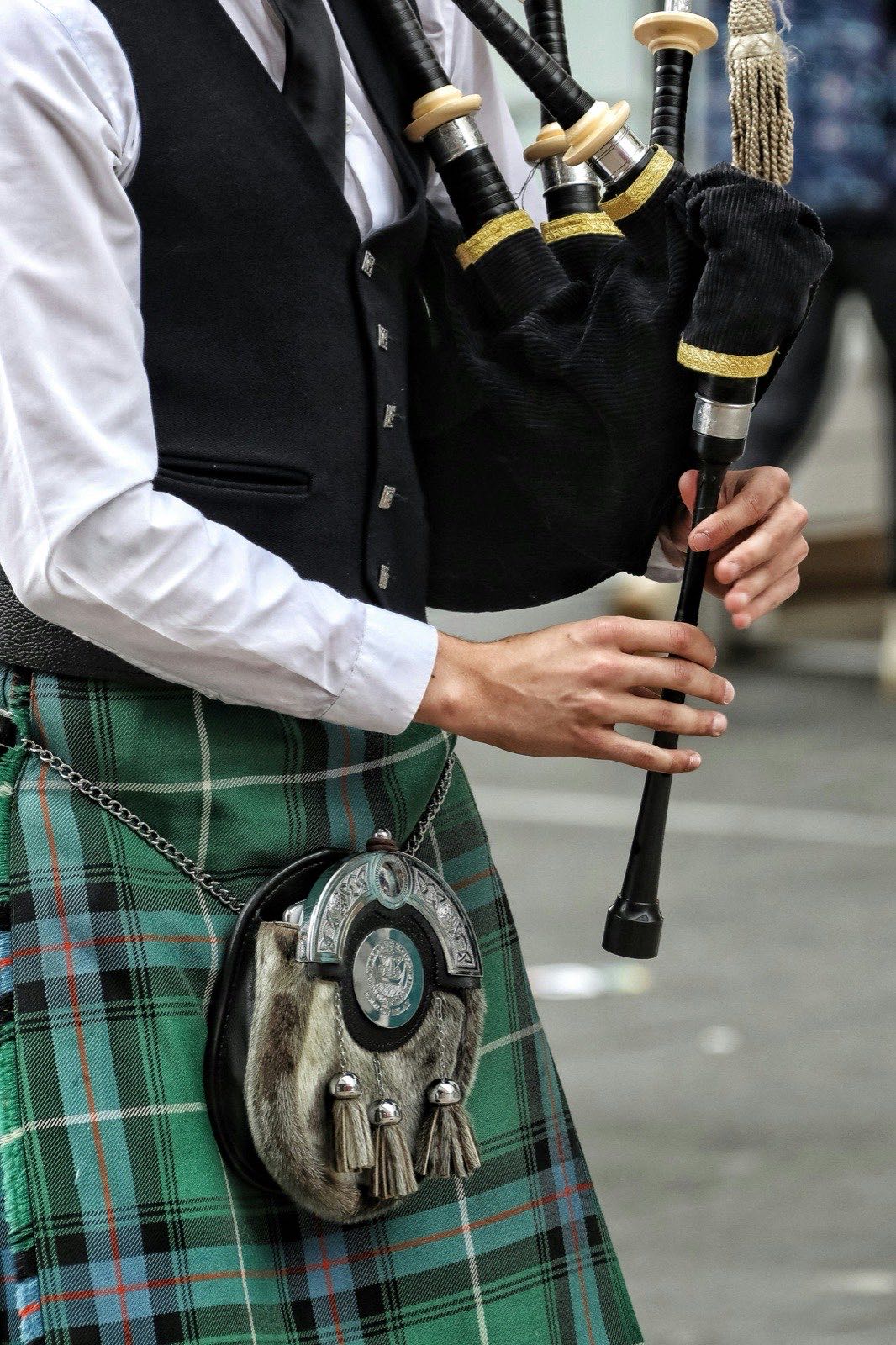 A bagpiper in a kilt holding the pipes, detail shot
